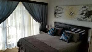 a bedroom with a bed and a large window at Villa Lucca in Cape Town