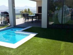 a house with a swimming pool and green grass at Villa Lucca in Cape Town