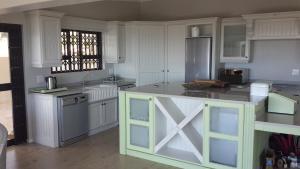 a large kitchen with white cabinets and a counter top at Villa Lucca in Cape Town