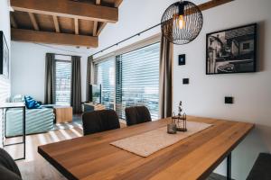 a dining room with a table and chairs and a large window at Bacher Living - Chalets & Apartments in Serfaus