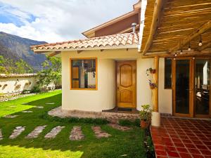una casa con una porta e un prato di Hotel and Country House Valle Sagrado de los Incas a Huaran