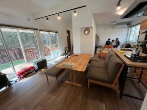 a living room with a table and a couch at BBQ可 ワンちゃんok ロフト付き平屋を貸切で楽しむ特別な空間 ハチん家 in Hokuto