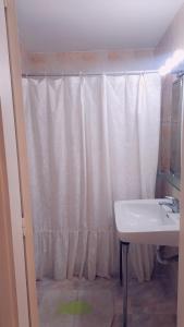 bagno con tenda da doccia bianca e lavandino di Depto Daria Punta del Este a Punta del Este
