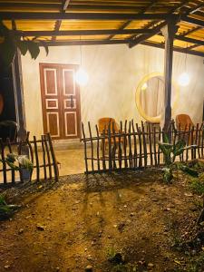 a room with a door and chairs and a fence at Dana's Villa in Ahangama