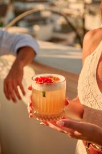 Eine Frau hält einen Drink in ihren Händen in der Unterkunft Hotel El Pilar Andalucia in Estepona