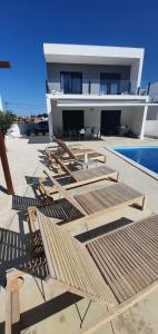 een huis met veel ligstoelen en een zwembad bij Casa Mikali in Alfeizerão