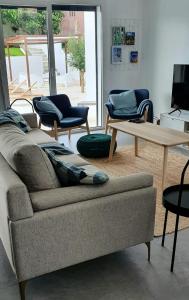 een woonkamer met een bank, een tafel en stoelen bij Casa Mikali in Alfeizerão