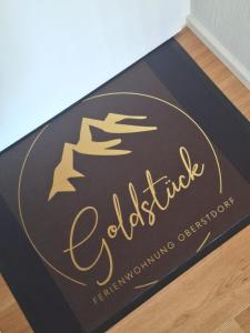 een zwart-gouden welkomstmat op de vloer bij Goldstück in Oberstdorf +19 foto's