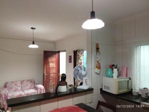 a living room with a couch and a microwave at Casa Praia Mongaguá in Mongaguá +44 photos