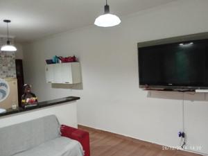 a living room with a couch and a flat screen tv at Casa Praia Mongaguá in Mongaguá