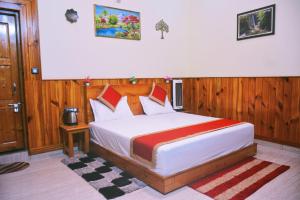 a bedroom with a large bed with wooden walls at Anurag Hotel in Chakrāta