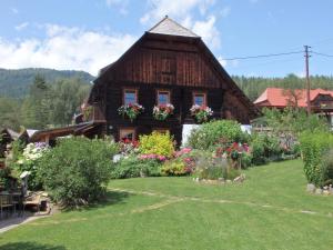 ein Holzhaus mit Blumen davor in der Unterkunft Casa Sauschneider in Sankt Ruprecht ob Murau