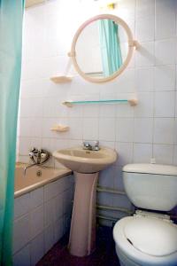 a bathroom with a toilet and a sink and a mirror at Granit Hotel in Vladivostok