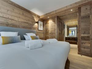 a large white bed in a room with wooden walls at Appartement 95m², Sud-Est, Jacuzzi, Val d'Isère, 4 Suites, Parking, Animaux OK - FR-1-567-73 in Val dʼIsère