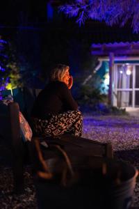 een oudere vrouw die 's nachts op een bankje zit bij Altillo Valizas in Barra de Valizas +49 foto's