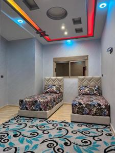 two beds sitting in a room with a rug at apartment for guests in Demnat