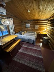 ein Schlafzimmer mit einem Bett in einer Blockhütte in der Unterkunft Cottages RukaTupa in Ruka