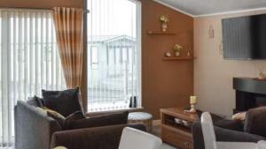 a living room with a couch and a television at Woodland Lodge in Plumbland