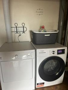 a laundry room with a washing machine and a basket on the wall at À 5 min de Moulins maison de ville in Yzeure +4 photos