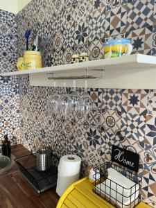 a kitchen with tiles on the wall and a yellow table at Ergzotic Apartments & Room in Sombor