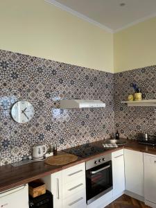 a kitchen with a clock on the wall at Ergzotic Apartments & Room in Sombor
