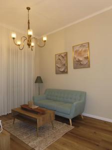 a living room with a blue couch and a coffee table at קאסה לונה בוטיק CASA LUNA boutique in Gan Yavneh