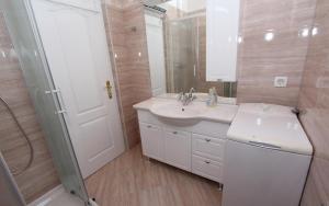 a white bathroom with a sink and a shower at Guest House Aurora in Rovinj +36 photos