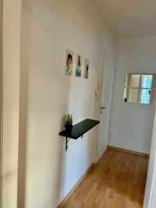 ein weißes Zimmer mit einem schwarzen Regal an der Wand in der Unterkunft 2-room apartment in Dresden's Neustadt in Dresden