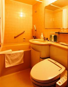uma casa de banho com um WC, um lavatório e uma banheira em Nest Hotel Matsuyama em Matsuyama