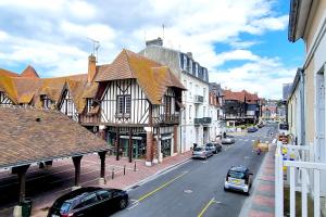 Una calle de la ciudad con coches aparcados en la calle. en Le Terranova - Maison hypercentre, en Deauville