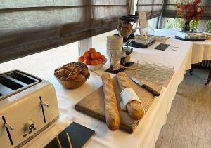 a table with bread and a cutting board on it at Hotel de l'Abbaye à Cluny in Cluny