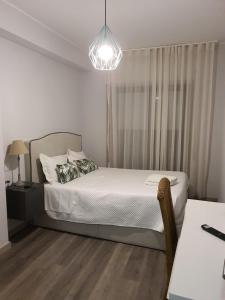 a bedroom with a bed and a chandelier at Beira Mar Loft in Aveiro