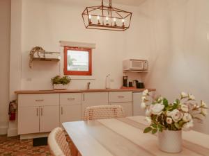 a kitchen with a table with a vase of flowers at Maison Rouge - Room 3 in Christiansted