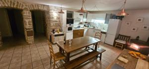 a kitchen with a wooden table and a dining room at Gîte La Grange in Saint-Laurent-dʼOlt