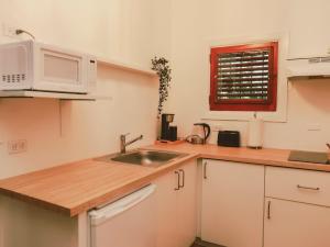 a kitchen with a sink and a microwave at Maison Rouge - Room 4 in Christiansted +15 photos