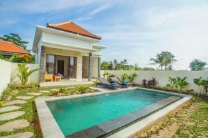 a swimming pool in front of a villa at Puri Arta Villa in Ubud