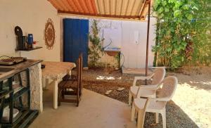 a kitchen with a table and chairs in a room at Casinha Guiné MorroSP in Morro de São Paulo