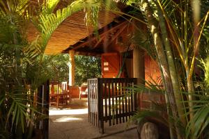 a porch of a house with a gate and plants at LA LOMA LINDA, Bungalows, Yoga and Feldenkrais, STARLINK INTERNET in Zipolite