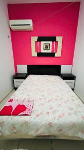 路易斯科雷亚Flat amarração 130的一间卧室配有一张粉红色墙壁的床