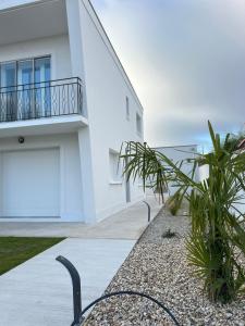 Cette maison blanche dispose d'un balcon donnant sur l'océan. dans l'établissement Appartement moderne et spacieux avec terrasse privée 1, à Carbon-Blanc