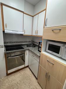 Una pequeña cocina con microondas y fregadero. en JTG PLAYA TORREVIEJA, en Torrevieja