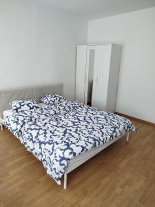 a bed with a blue and white comforter in a bedroom at Chambre disponible in Aalst