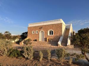 a brick house with stairs in the desert at The Mogador's Oasis in Akermoud