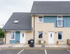 una casa azul con un cubo de basura delante de ella en Kirkwall Studios - Studio 29A, en Kirkwall