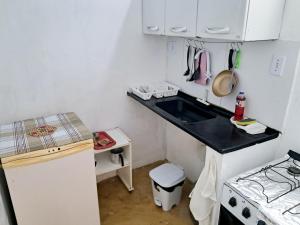 een kleine keuken met een spoelbak en een fornuis bij Casinha Guiné in Morro de São Paulo
