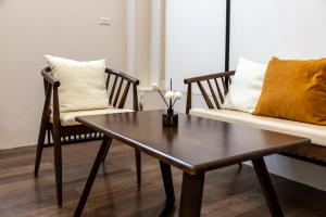 a table and chairs in a living room with a couch at 2 Indochine Design Apartment - Hanoi Old Quarter in Hanoi