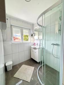 a bathroom with a glass shower and a sink at Apartman VITO in Trebinje +53 photos