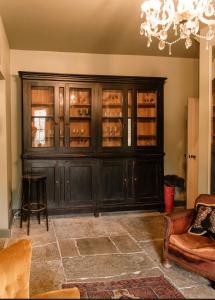 マートックにあるEscape to Ash House 18th Century Manor in Somersetの大きな黒いキャビネット(ガラスドア付)