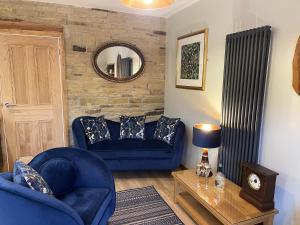 a living room with a blue couch and a mirror at Weavers Rest - New Boutique Retreat in Central Skipton with Parking in Skipton