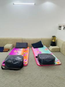 two beds sitting on the floor next to a couch at استراحة سعد للايجار اليومي in Jubbah